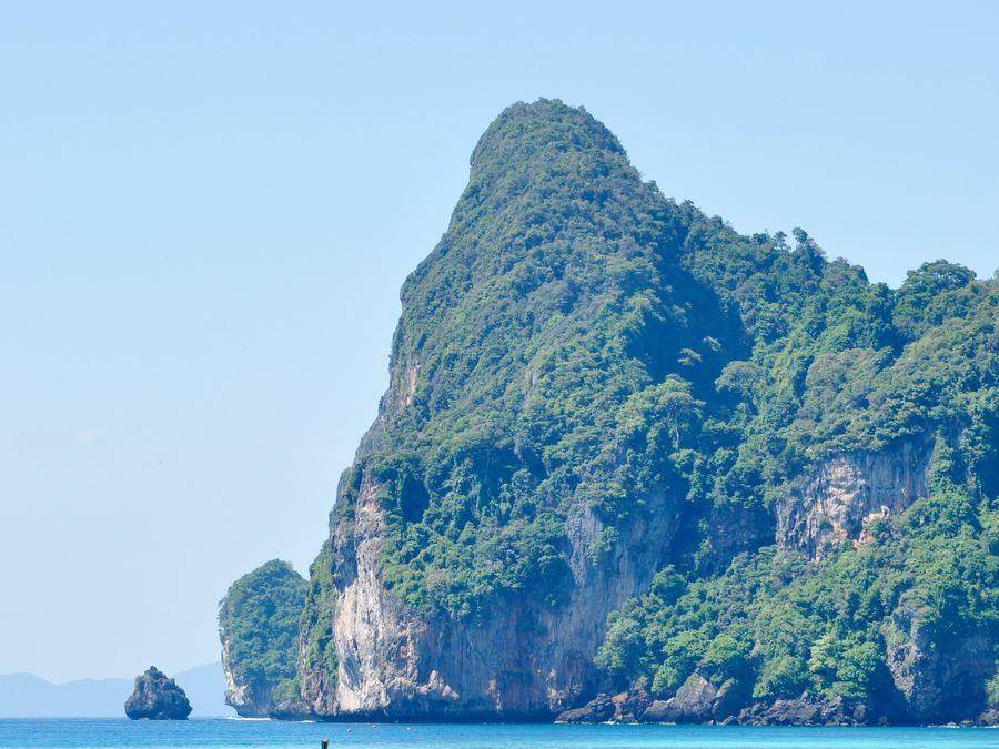 Turquoise sea by a green rocky island